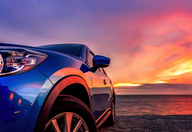 Closeup of a blue car at sunset