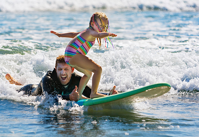 Father and girl surfing