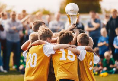 Kids celebrating soccer championship win with trophy