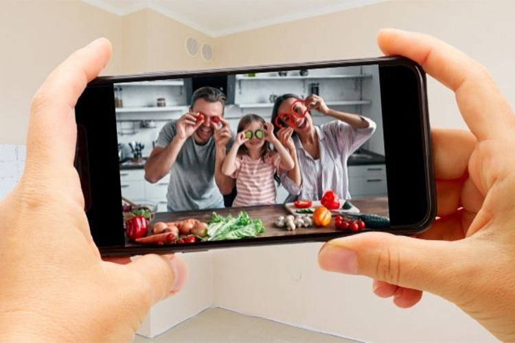 Family in kitchen holding vegetables on their eyes